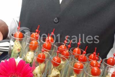 Cuisine professionnelle avec plans de travail en inox, évier, robinet flexible et porte de sortie au fond.