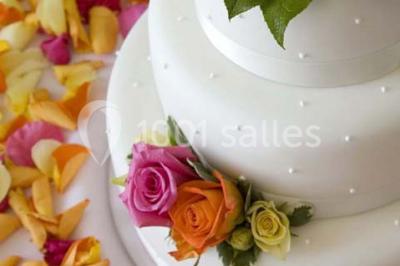 Cuisine professionnelle avec plans de travail en inox, évier, robinet flexible et porte de sortie au fond.