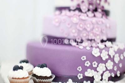 Cuisine professionnelle avec plans de travail en inox, évier, robinet flexible et porte de sortie au fond.