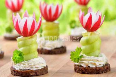 Cuisine professionnelle avec plans de travail en inox, évier, robinet flexible et porte de sortie au fond.