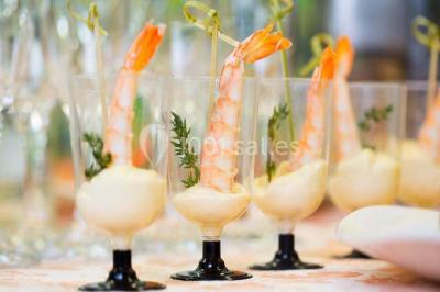 Cuisine professionnelle avec plans de travail en inox, évier, robinet flexible et porte de sortie au fond.