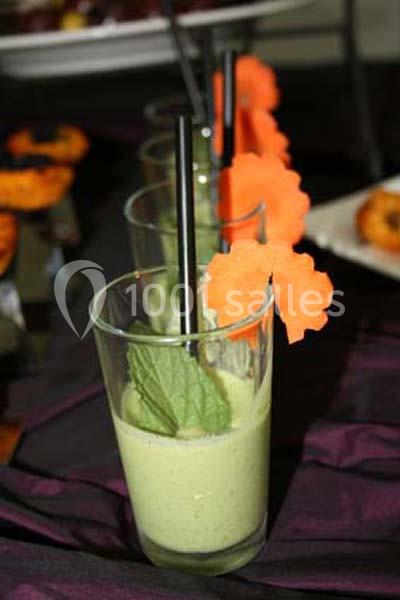 Verres de soupe verte garnis de feuilles de menthe et décorés de tranches de carotte en forme de fleur.