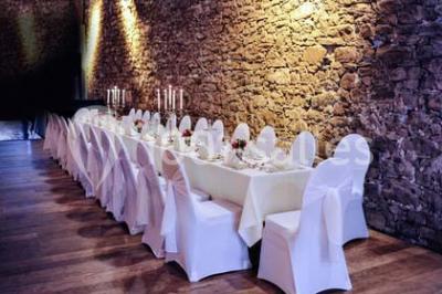 Cuisine professionnelle avec plans de travail en inox, évier, robinet flexible et porte de sortie au fond.