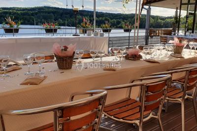 Cuisine professionnelle avec plans de travail en inox, évier, robinet flexible et porte de sortie au fond.