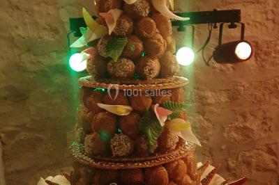 Cuisine professionnelle avec plans de travail en inox, évier, robinet flexible et porte de sortie au fond.