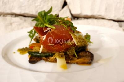 Cuisine professionnelle avec plans de travail en inox, évier, robinet flexible et porte de sortie au fond.