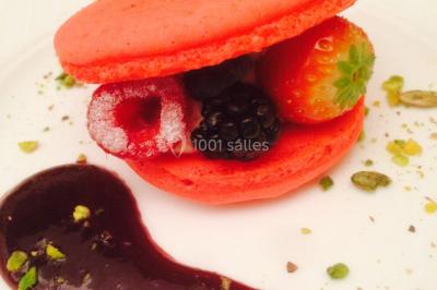 Cuisine professionnelle avec plans de travail en inox, évier, robinet flexible et porte de sortie au fond.