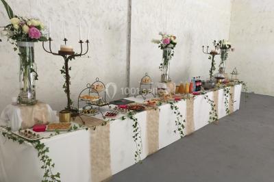 Cuisine professionnelle avec plans de travail en inox, évier, robinet flexible et porte de sortie au fond.