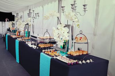 Cuisine professionnelle avec plans de travail en inox, évier, robinet flexible et porte de sortie au fond.