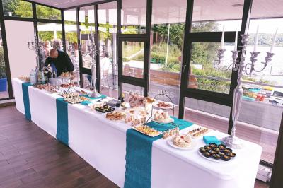 Cuisine professionnelle avec plans de travail en inox, évier, robinet flexible et porte de sortie au fond.