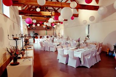 Cuisine professionnelle avec plans de travail en inox, évier, robinet flexible et porte de sortie au fond.