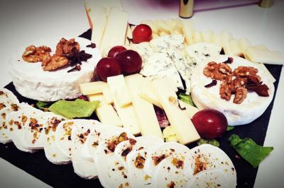 Cuisine professionnelle avec plans de travail en inox, évier, robinet flexible et porte de sortie au fond.