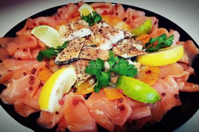 Cuisine professionnelle avec plans de travail en inox, évier, robinet flexible et porte de sortie au fond.