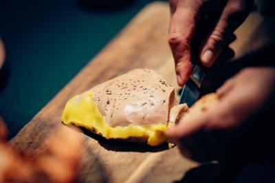 Bol de farine, fouet métallique, citrons, zesteur, beurre et noisettes posés sur une planche en bois.