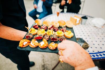 Bol de farine, fouet métallique, citrons, zesteur, beurre et noisettes posés sur une planche en bois.