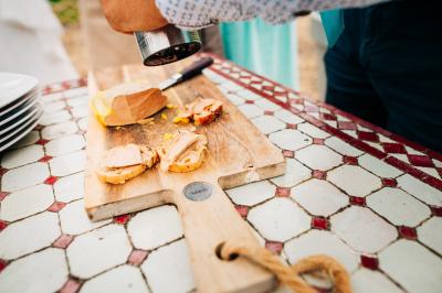 Bol de farine, fouet métallique, citrons, zesteur, beurre et noisettes posés sur une planche en bois.