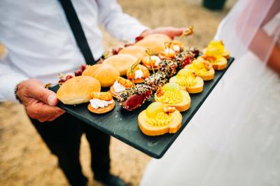 Bol de farine, fouet métallique, citrons, zesteur, beurre et noisettes posés sur une planche en bois.