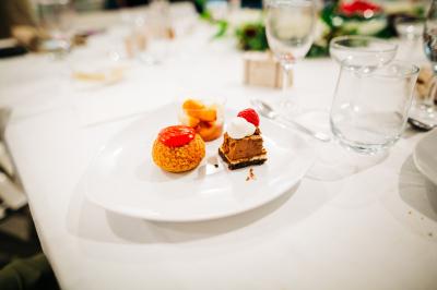 Bol de farine, fouet métallique, citrons, zesteur, beurre et noisettes posés sur une planche en bois.