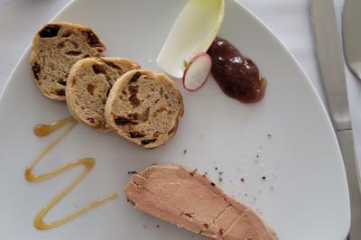 Bol de farine, fouet métallique, citrons, zesteur, beurre et noisettes posés sur une planche en bois.