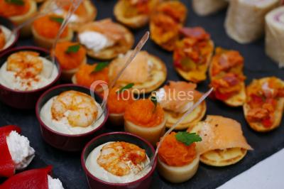 Bol de farine, fouet métallique, citrons, zesteur, beurre et noisettes posés sur une planche en bois.