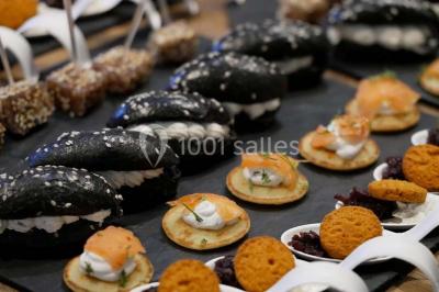 Bol de farine, fouet métallique, citrons, zesteur, beurre et noisettes posés sur une planche en bois.