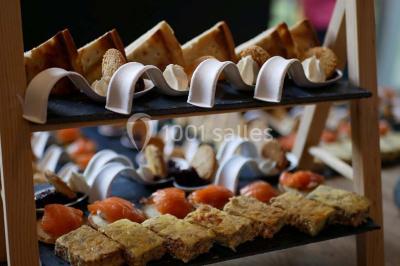 Bol de farine, fouet métallique, citrons, zesteur, beurre et noisettes posés sur une planche en bois.