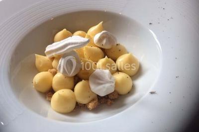 Bol de farine, fouet métallique, citrons, zesteur, beurre et noisettes posés sur une planche en bois.