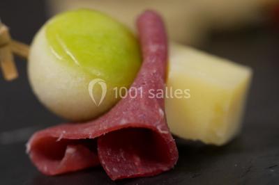 Bol de farine, fouet métallique, citrons, zesteur, beurre et noisettes posés sur une planche en bois.