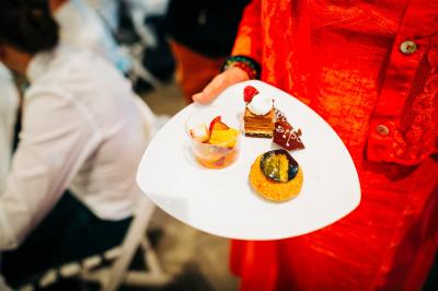 Bol de farine, fouet métallique, citrons, zesteur, beurre et noisettes posés sur une planche en bois.