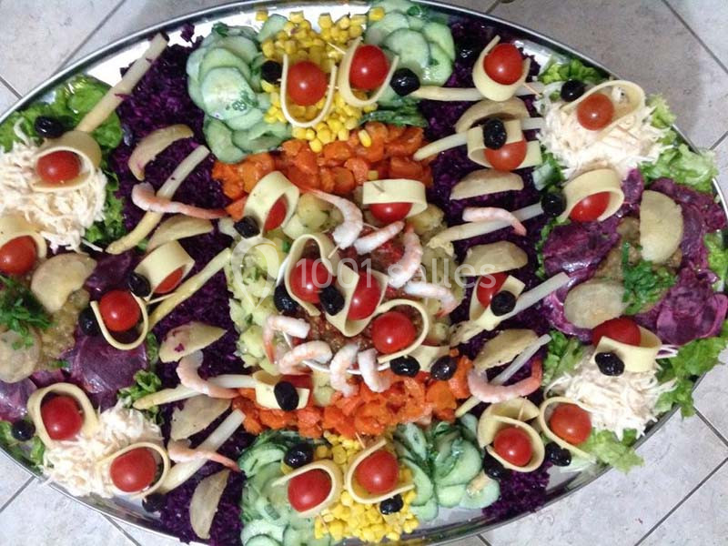Plateau de crudités variées avec légumes colorés, crevettes, tomates cerises, olives et tranches de fromage.