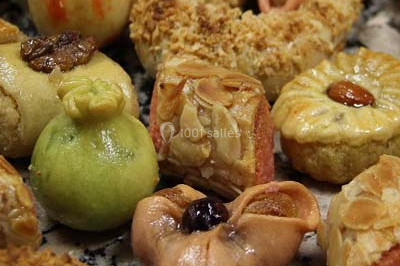 Assiette garnie de riz décoré de radis et tomates cerises, entourée de samoussas, crevettes et œufs de caille.