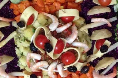 Assiette garnie de riz décoré de radis et tomates cerises, entourée de samoussas, crevettes et œufs de caille.