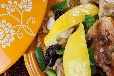 Assiette garnie de riz décoré de radis et tomates cerises, entourée de samoussas, crevettes et œufs de caille.