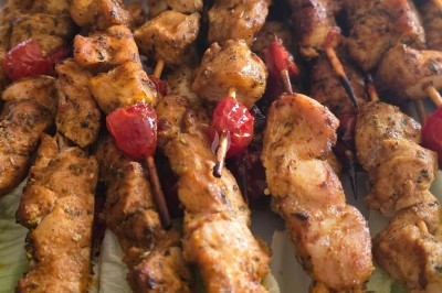 Assiette garnie de riz décoré de radis et tomates cerises, entourée de samoussas, crevettes et œufs de caille.