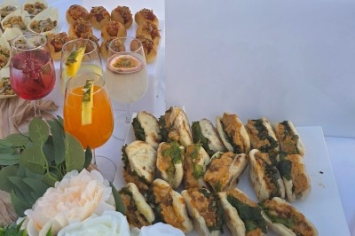 Assiette garnie de riz décoré de radis et tomates cerises, entourée de samoussas, crevettes et œufs de caille.