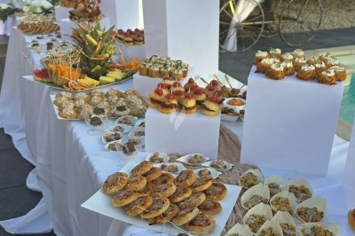 Assiette garnie de riz décoré de radis et tomates cerises, entourée de samoussas, crevettes et œufs de caille.