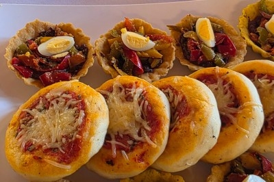 Assiette garnie de riz décoré de radis et tomates cerises, entourée de samoussas, crevettes et œufs de caille.