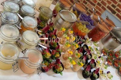 Dessert décoré avec des macarons, fraises, feuilles en chocolat, fleurs comestibles et touches de feuilles d'or.
