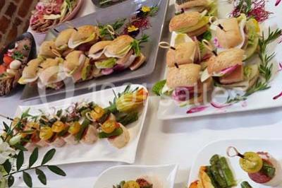 Dessert décoré avec des macarons, fraises, feuilles en chocolat, fleurs comestibles et touches de feuilles d'or.