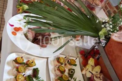 Dessert décoré avec des macarons, fraises, feuilles en chocolat, fleurs comestibles et touches de feuilles d'or.