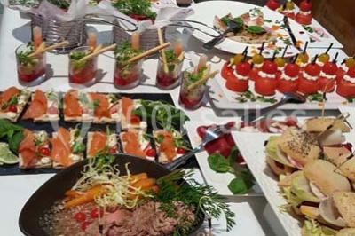Dessert décoré avec des macarons, fraises, feuilles en chocolat, fleurs comestibles et touches de feuilles d'or.
