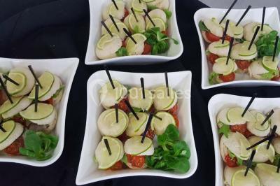 Dessert décoré avec des macarons, fraises, feuilles en chocolat, fleurs comestibles et touches de feuilles d'or.