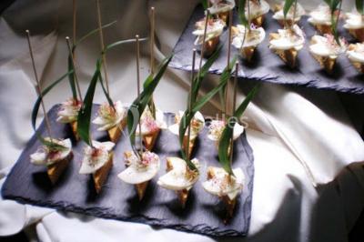 Dessert décoré avec des macarons, fraises, feuilles en chocolat, fleurs comestibles et touches de feuilles d'or.