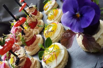 Dessert décoré avec des macarons, fraises, feuilles en chocolat, fleurs comestibles et touches de feuilles d'or.