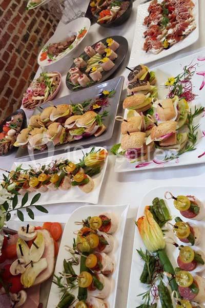 Buffet de plats variés avec canapés, légumes farcis, brochettes et assortiments colorés sur une table blanche.