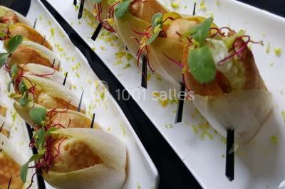 Dessert décoré avec des macarons, fraises, feuilles en chocolat, fleurs comestibles et touches de feuilles d'or.