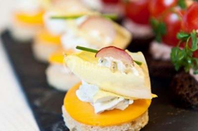 Dessert décoré avec des macarons, fraises, feuilles en chocolat, fleurs comestibles et touches de feuilles d'or.