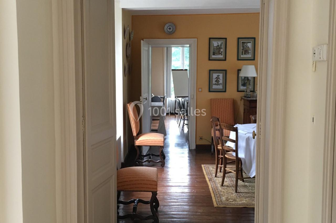 Vue d'un intérieur lumineux avec des murs jaunes, des meubles en bois et une table dressée dans une salle à manger.