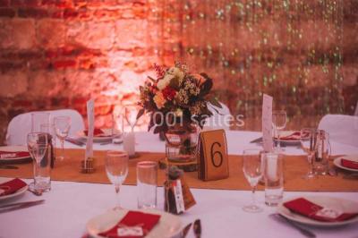 Tour en briques avec toit en ardoise, entourée de bâtiments ruraux et d'arbres, sous un ciel dégagé.