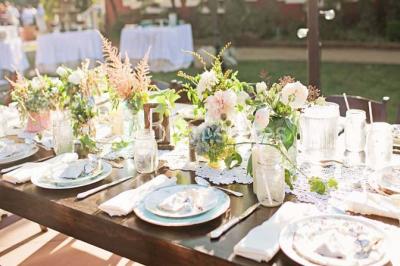 Tour en briques avec toit en ardoise, entourée de bâtiments ruraux et d'arbres, sous un ciel dégagé.